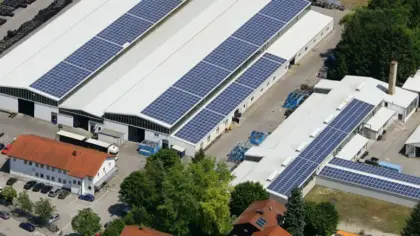 Firmengelaende von Huber Technik von oben. Hallen mit Photovoltaikanlagen auf dem Dach.